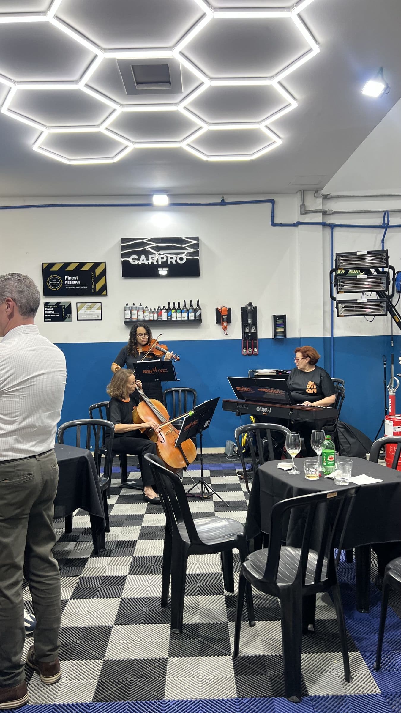 Trio de músicos com violino, violoncelo e teclado durante o UtaBar #02.