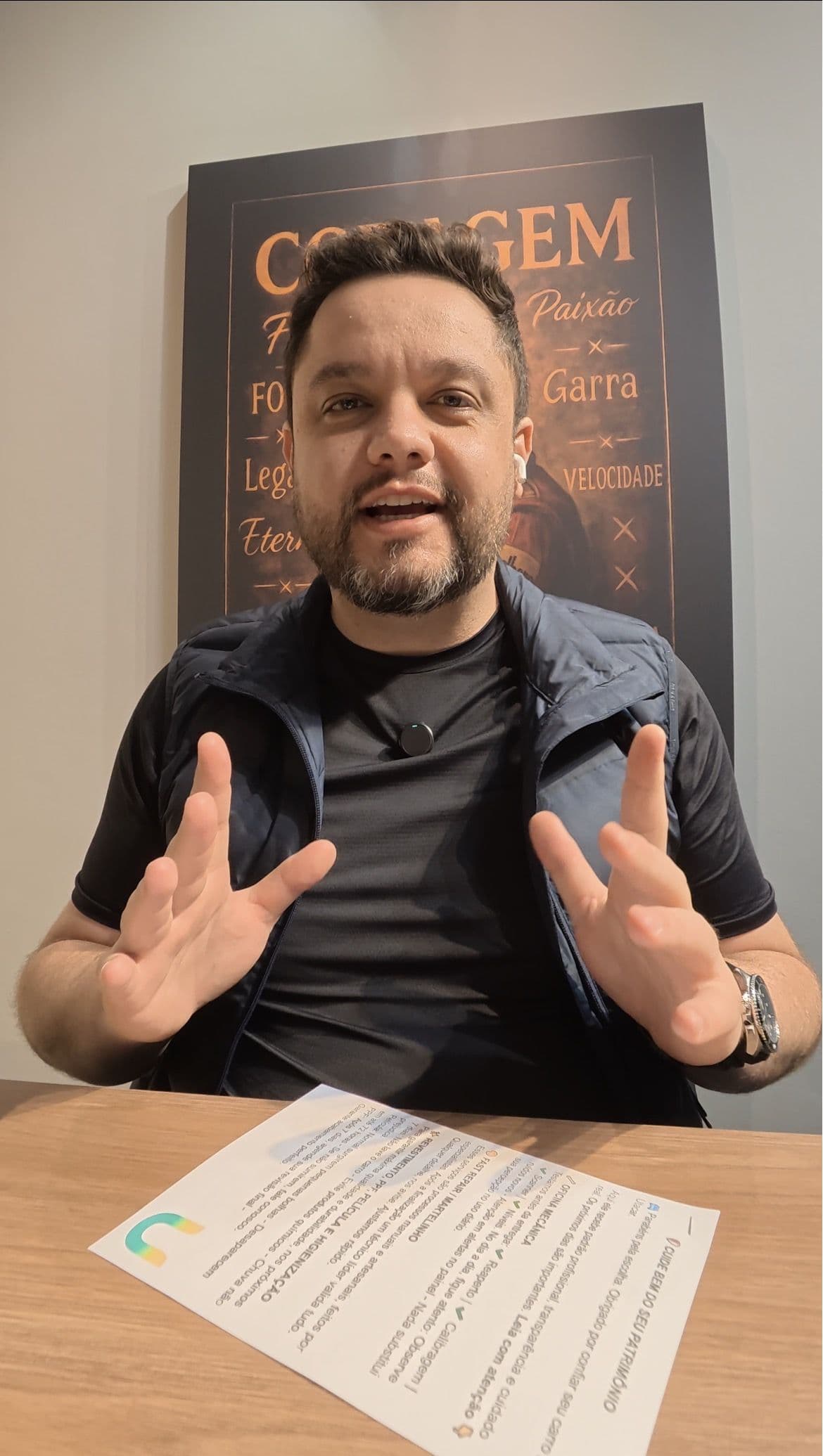 Gustavo Agiessi, gestor da Utacar, sentado à mesa durante uma conversa, com o quadro Coragem na parede ao fundo.
