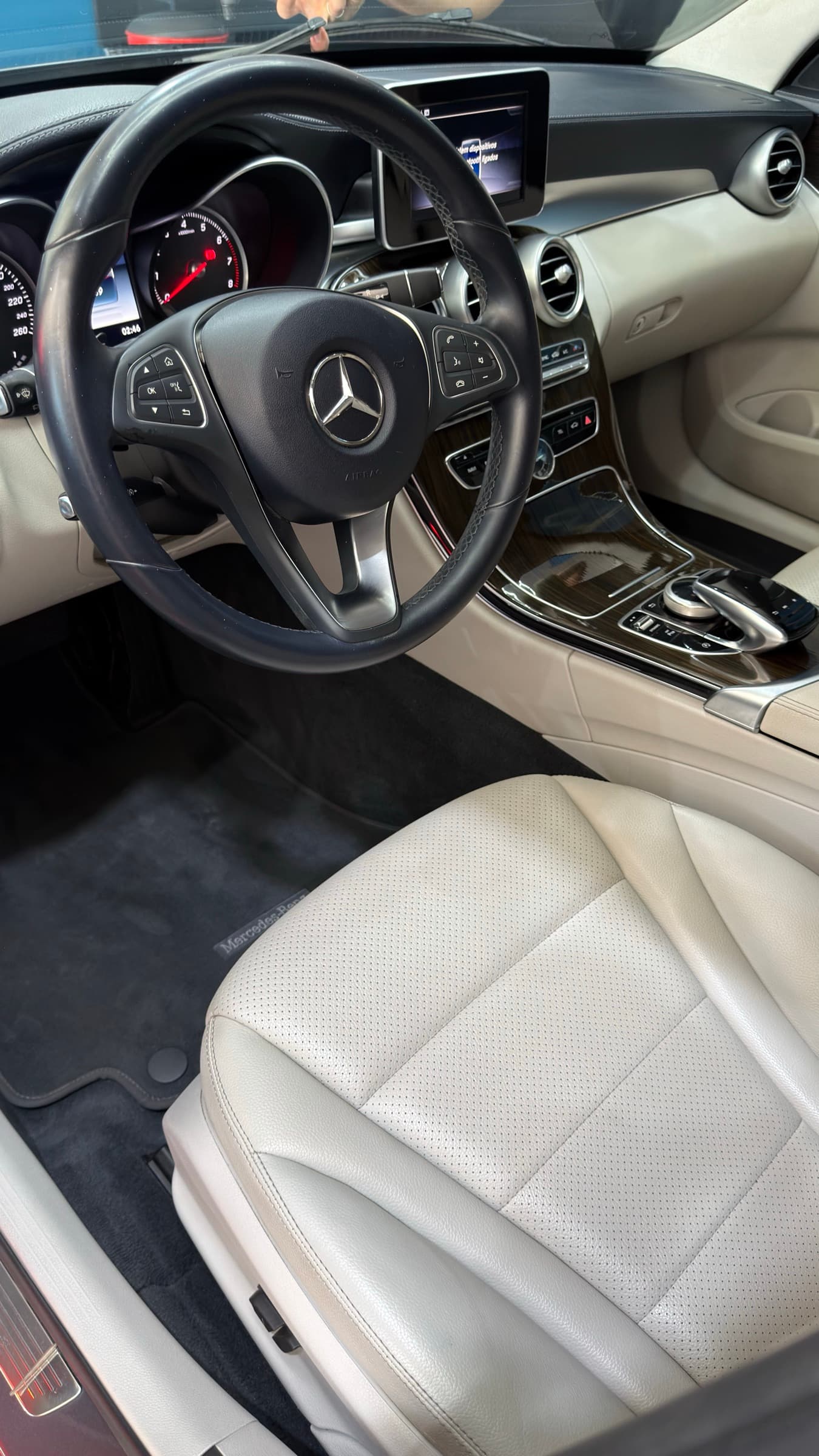 Interior bege de um carro depois da higienização, com bancos, painel e carpete limpos.