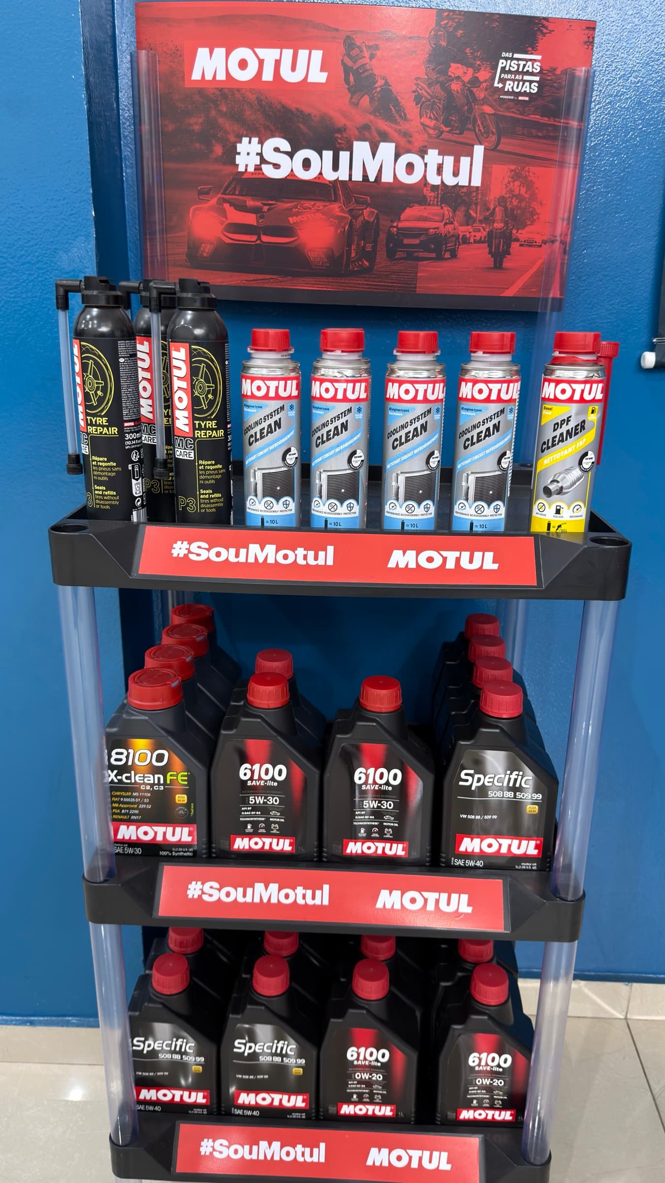 Expositor da Motul na loja, com os frascos de óleo alinhados nas prateleiras.